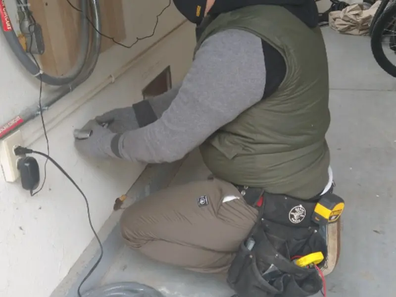 Electrician performing outlet wiring in a Orange Beach garage
